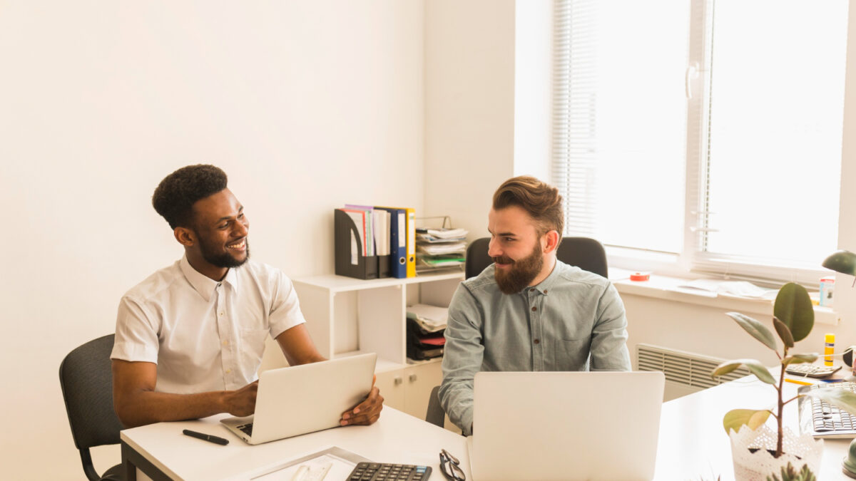hommes utilisant ordinateurs portables bavardant