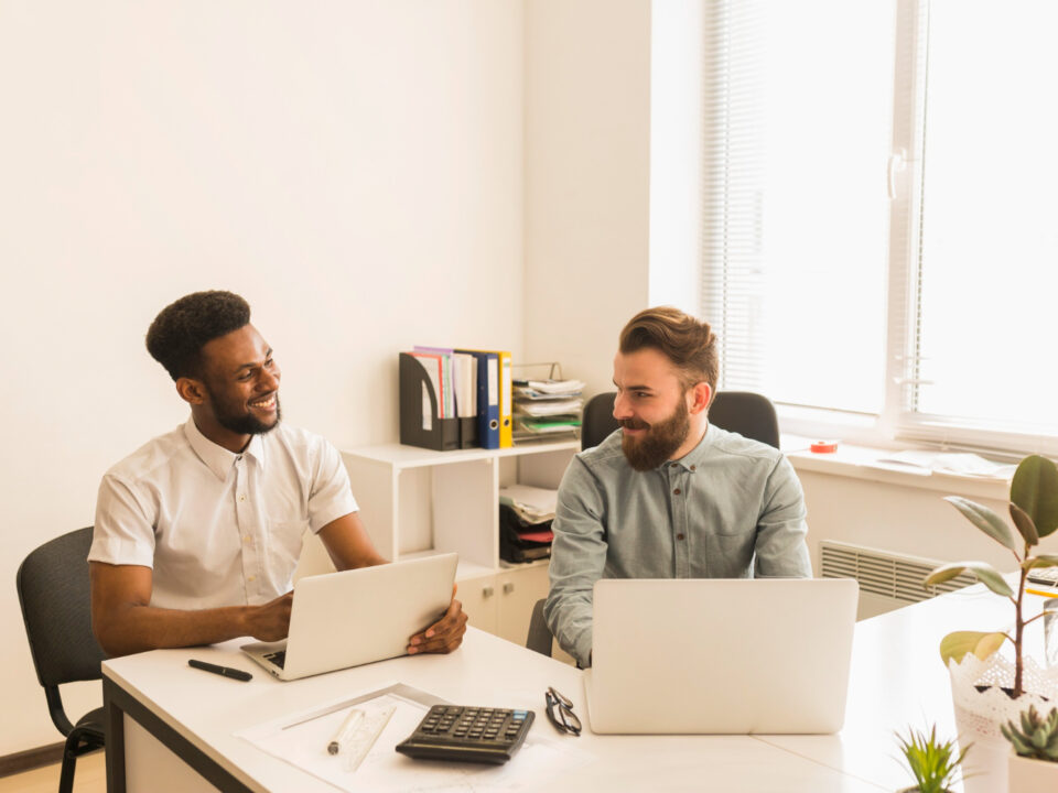 hommes utilisant ordinateurs portables bavardant